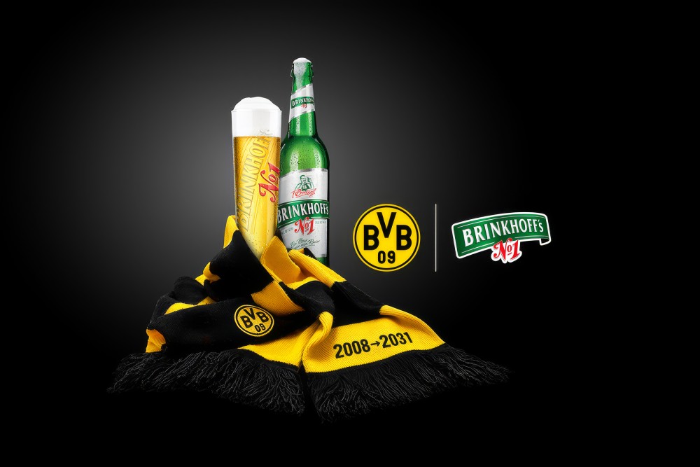 Eine Flasche Brinkhoffs und ein Brinkhoffs Glas umwickelt mit einem BVB Schaal.