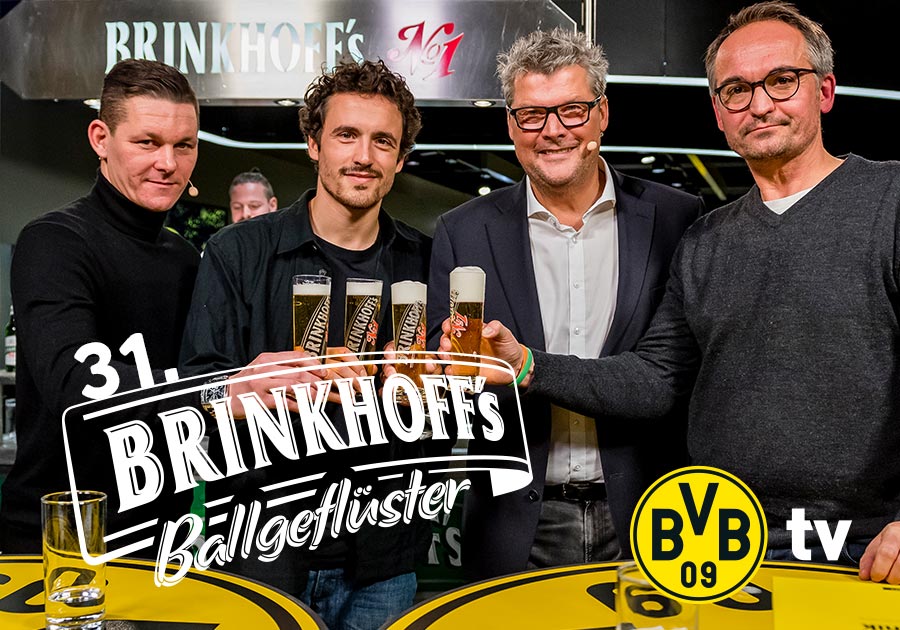Vier Männer stehen an einer Bar und halten Gläser mit Getränken.