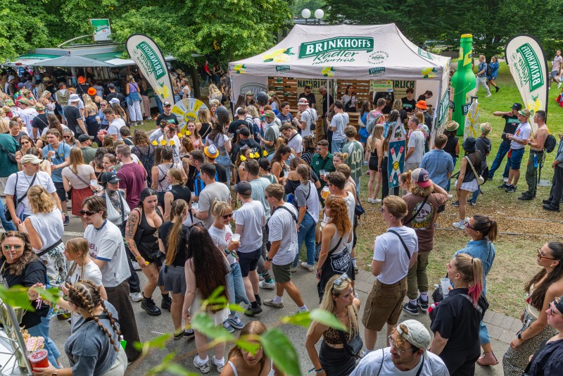 Ein Park mit feiernden Menschen, Im Hintergrund Brinkhoff's Zelte