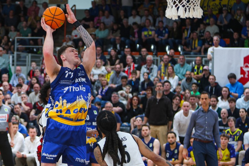 Basketballspieler wirft einen Korb während eines Basketballspiels in einer Halle