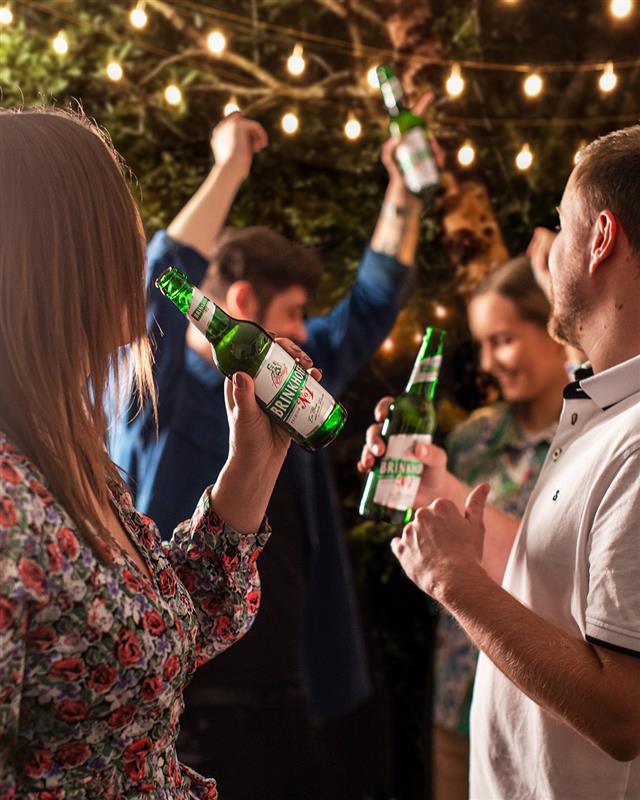 Eine Collage zeigt verschiedene Werbeaktionen für ein Bier, darunter Menschen, die Bierflaschen halten und ein Basketballteam.