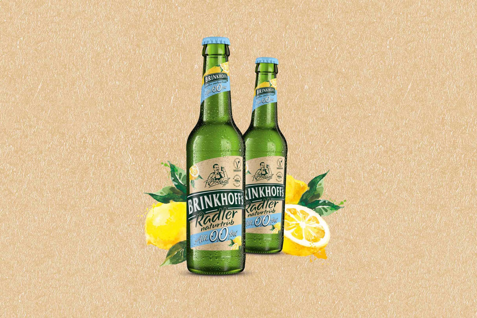 Zwei Flaschen naturtrübes Radler mit 0,0 Prozent Alkohol, daneben Lemonen mit Blättern.